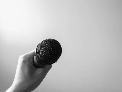Close-up microphone in left hand of singer at concert with copy space. Stock Photos