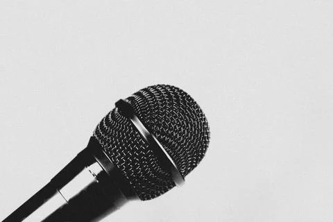 Close-up of a microphone on a plain white background. Film grain cinematic. Foto stock
