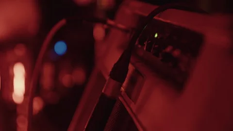 Close up of microphone plugged into amplifier with red light on stage during Stock Footage 341172607