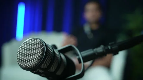 Close-Up Microphone with Speaker in Blurred Background Setting in Recording Stock Footage 336942878