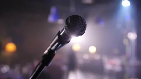 Close-up of microphone on stage against a black background with white lighting. Stock-Footage 229556426