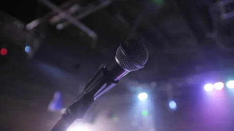 Close-up of microphone on stage against a black background with white lighting. Stock-Footage 229556429