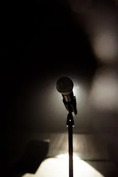 Close up of microphone on stage in black background Stock Photos