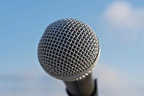 Close-Up Microphone on Stand Against Vibrant Blue Sky with Fluffy White Clouds Stock Photos