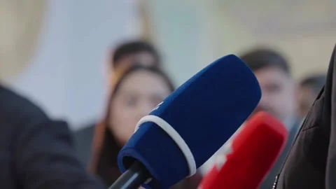 Close up of microphones directed toward executive spokesperson, with numerous Stock Footage 337062036