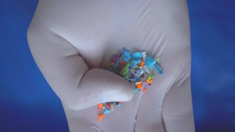 Close-up of microplastic particles in person's hand wearing medical gloves. Vidéo 241065747