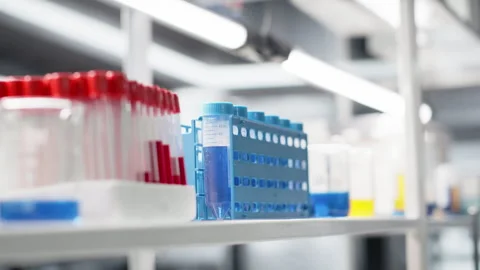 Close up of microscope in lab next to computer monitor displaying DNA data Stock Footage 320143147