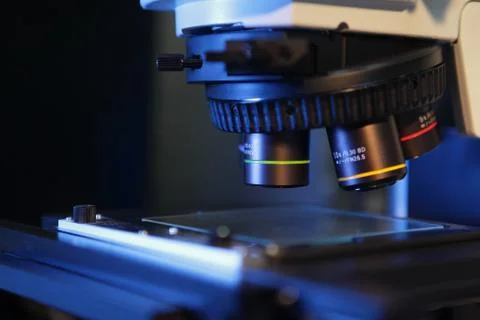 Close up of microscope lenses focused on a specimen in blue light Fotos Stock