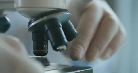 Close up of microscope oculars being directed at a sample on a piece of glass Stock Footage 142785678