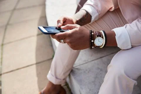 Close up mid section of man in a pink suit using smartphone Stock Photos