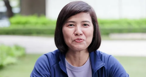 Close up of middle-aged Beautiful Asian woman short hair talking with confidence Stock Footage 163661463
