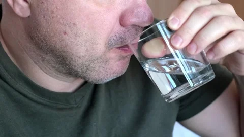 Close up middle aged man drinking water from glass indoors Video stock 312807566