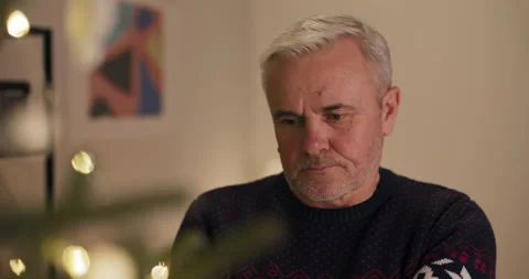 Close-up of middle-aged man with gray hair standing and looking at Christmas 스톡 동영상 210585162