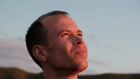 Close-up of a middle-aged man looking up at the sky in the mountains Stock Footage 229236016