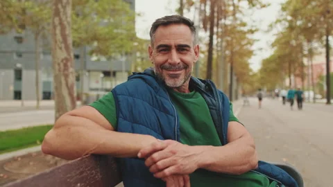 Close up, middle-aged man resting sitting on bench in the park Stockbeeldmateriaal 244686494