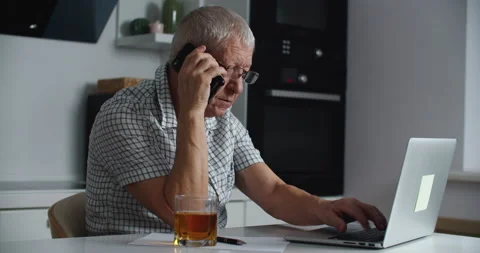 Close up of middle aged man wearing glasses is working on a laptop and talking Stock Footage 146409928