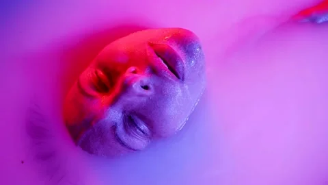 Close-up of a middle-aged woman's face, she lies in a milk bath in a spa salon 動画素材 236889485