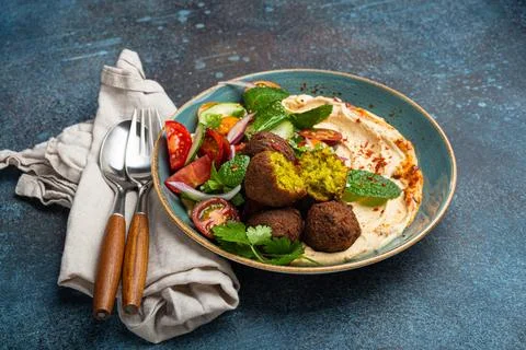 Close up of Middle Eastern Arab meal with fried falafel, hummus, vegetables Stock Photos