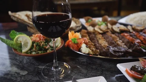 Close-up of middle eastern dishes served on a table with wine Stock Footage 129928069
