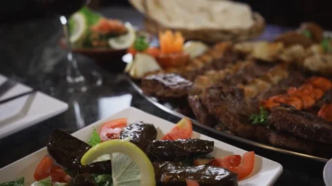 Close-up of middle eastern dishes served on a table with wine Stock Footage 129928081