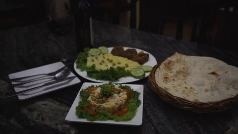 Close-up of middle eastern dishes served on a table with naan Stock Footage 129928101