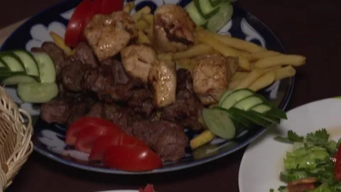 Close-up of middle eastern platter of kebab, potatoes, hummus, salad, pita. Video stock 88866195