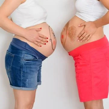 Close-up midsection of  two  young caucasian pregnant  women  with  face of s Stock Photos