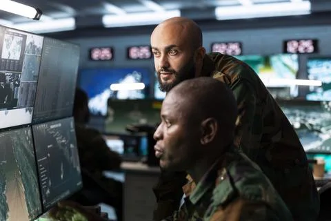 Close up of military command post team reviewing surveillance data Stock Photos