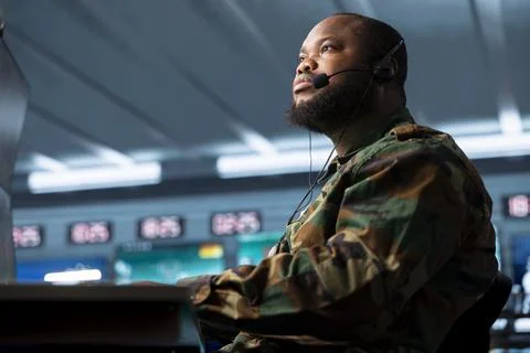 Close up of military operator receiving intel, listening through headset Stock Photos