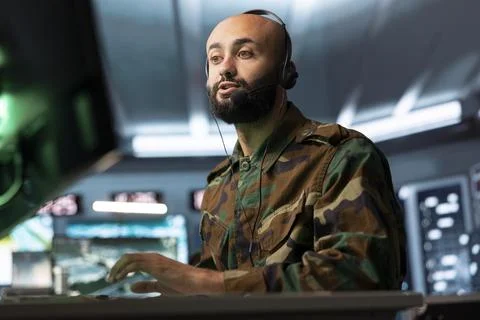 Close up of military operator speaking through headset mic in control room Stock Photos