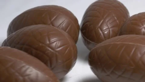Close-up of milk chocolate Easter eggs rotating on a white plate, showcasin.. Stock Footage 340072270
