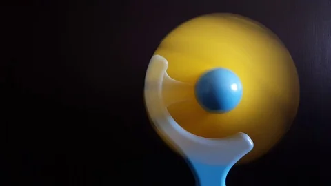 Close up of a mini blue and yellow electric fan spinning on black background Stock Footage 94170635