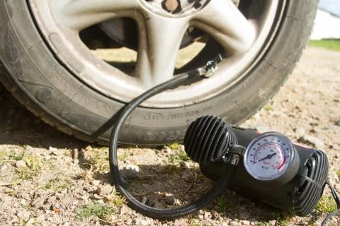 Close up of a mini compressor with pressure gauge which inflates the car tir Foto stock