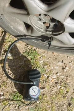 Close up of a mini compressor with pressure gauge which inflates the car tir Stock Photos