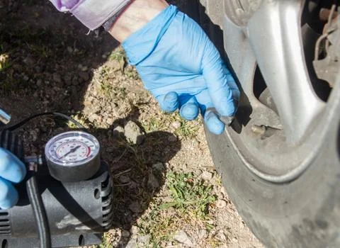 Close up of a mini compressor with pressure gauge which inflates the car tir Stock Photos