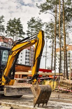 Close-up mini excavator during the construction of a modern residential compl Photos