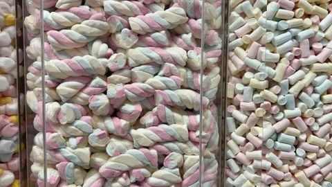 Close-up of mini marshmallows in two colors on a pink background in rotation. Vídeo Stock 316086639