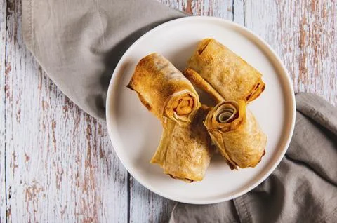 Close up of mini rolls of lavash, bacon and cheese on a plate on the table top Stock Photos