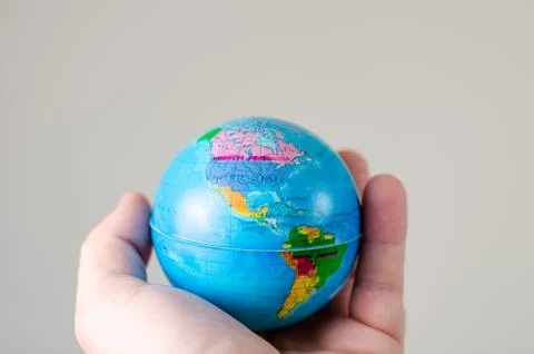 Close-up   of  miniature globe held in hand with the map of America  . Stock Photos