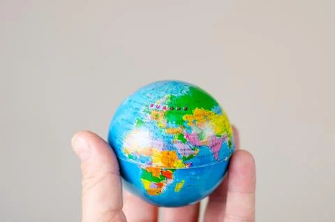 Close-up   of  miniature globe held in hand with the map of Europe  . Stock Photos