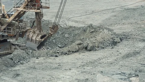 Close-up of mining excavator scooped up the ore with a bucket. Quarry mining Stock Footage 99712366
