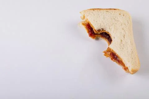 Close-up of missing bite on peanut butter and jelly sandwich over white Stock Photos