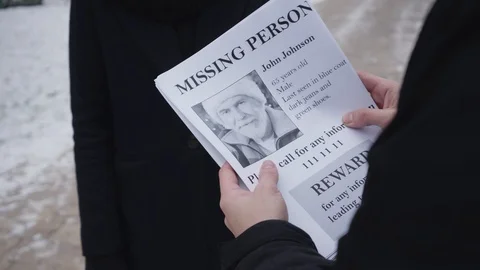 Close-up of missing person ad given by unrecognizable man to young Caucasian Stock Footage 123008483