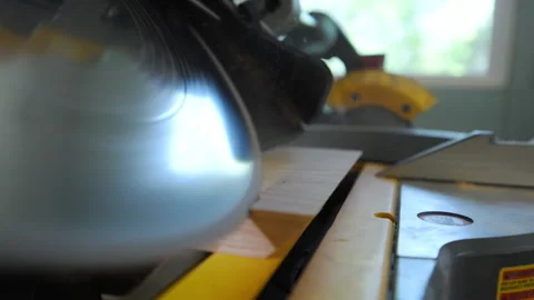 Close-up of a miter saw cutting through a piece of wood with 45 degrees angle Vidéo 320145890