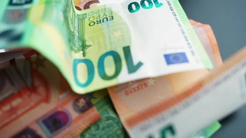 Close-up of mixed euro banknotes on a dark table with copy space and shallow Vidéo 328910771