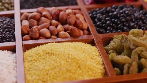 Close-up of Mixed Grains and Nuts Arranged in Wooden Compartments Stockbeeldmateriaal 336560443