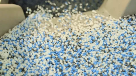 Close-up of mixed polymer pellets flowing in industrial hopper indoors Vídeo Stock 342604576