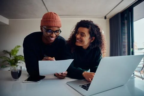 Close up of mixed race couple using laptop for online banking. Happy African Stock Photos