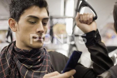 Close Up Of Mixed Race Man Text Messaging With Cell Phone On Subway