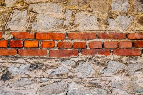 Close-up of mixed stone and red brick masonry wall with weathered texture a.. Stock Photos